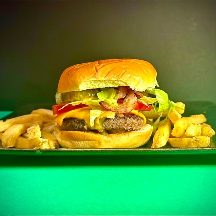 Our irresistible classic featuring a perfectly cooked 3oz beef patty, melted cheese, fresh tomatoes, sliced onions, crunchy gherkins, and a generous drizzle of our signature house sauce, all on a toasted bun.