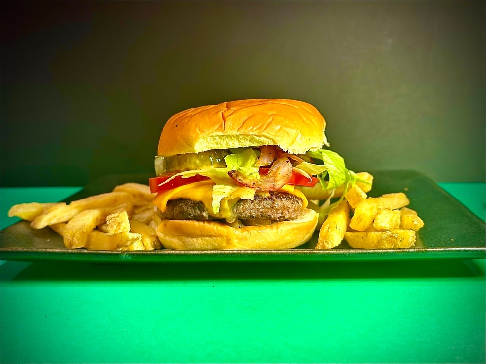 Our irresistible classic featuring a perfectly cooked 3oz beef patty, melted cheese, fresh tomatoes, sliced onions, crunchy gherkins, and a generous drizzle of our signature house sauce, all on a toasted bun.
